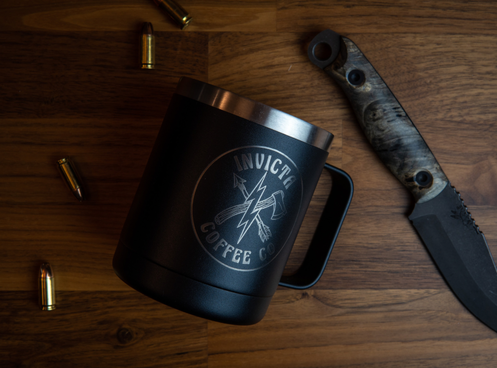 Black insulated coffee mug featuring Invicta coffee's hatchet and arrow logo. 